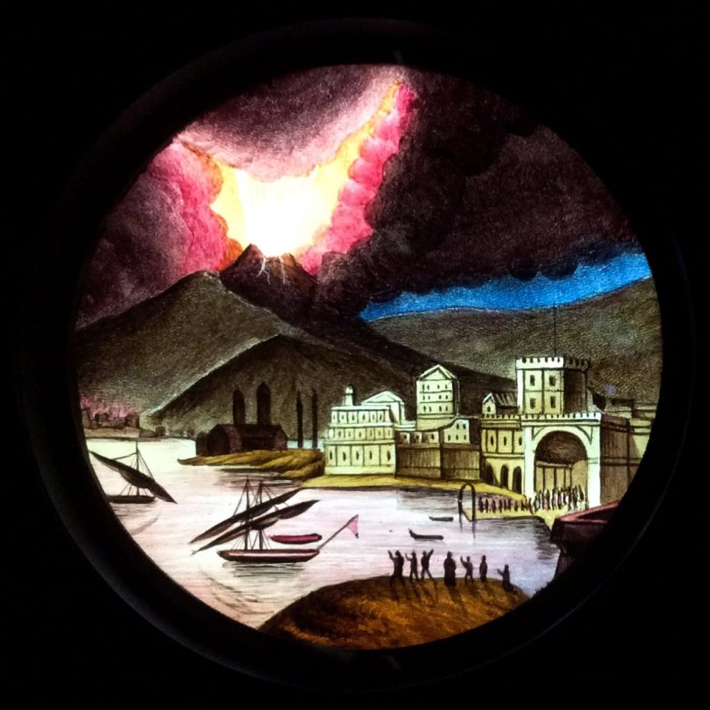 Das auf Glas gemaltes Bild für eine Laterna Magica zeigt den Ausbruch des Vesuv.